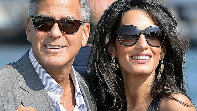 US actor George Clooney ( L) and his Lebanon-born British fiancee Amal Alamuddin take a taxiboat upon their arrival in Venice on September 26, 2014, on the eve of their wedding.    AFP PHOTO / ANDREAS SOLARO        (Photo credit should read ANDREAS SOLARO/AFP via Getty Images)