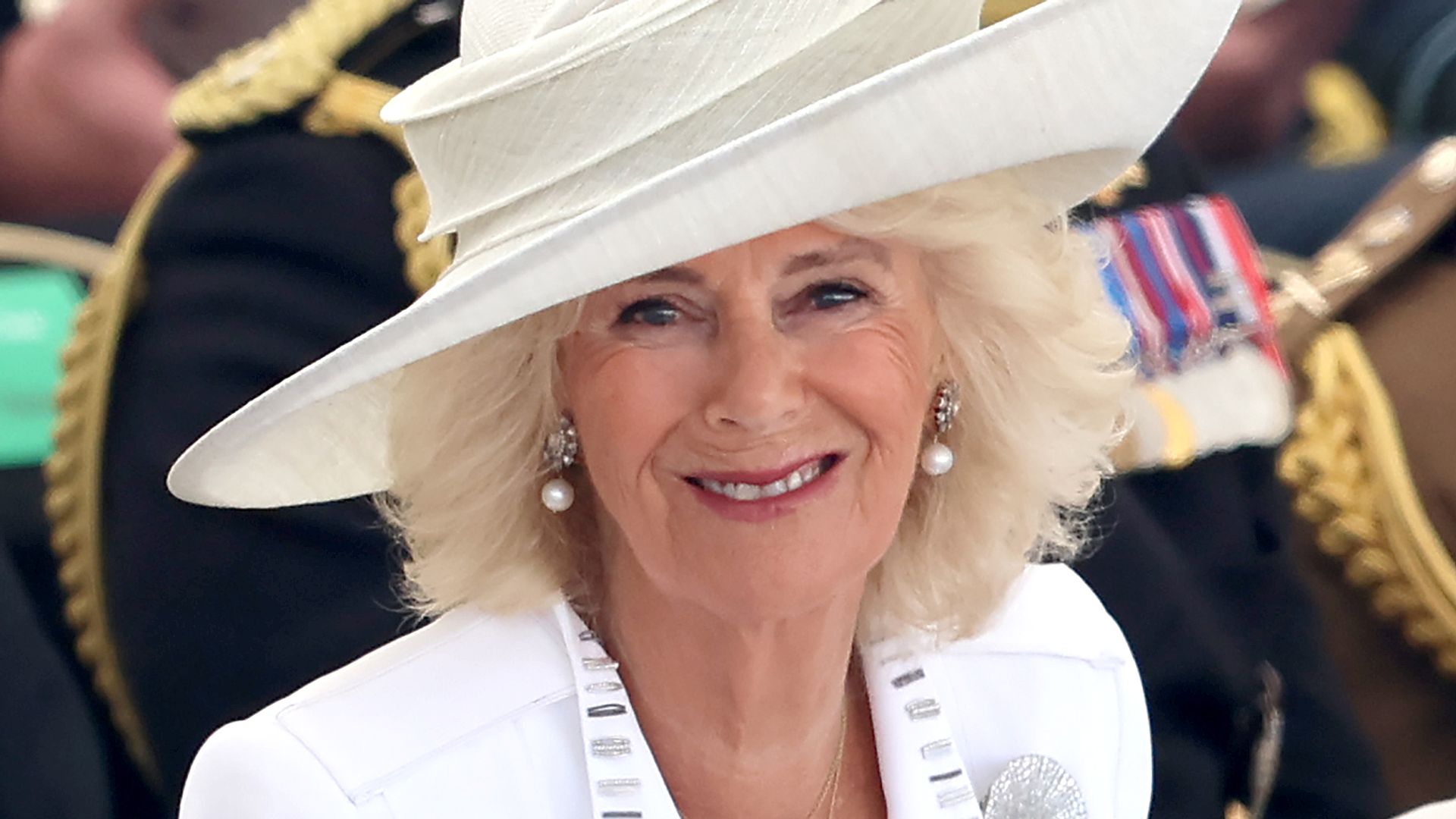 Queen Camilla steps out with divisive slogan accessory at Hampton Court Palace
