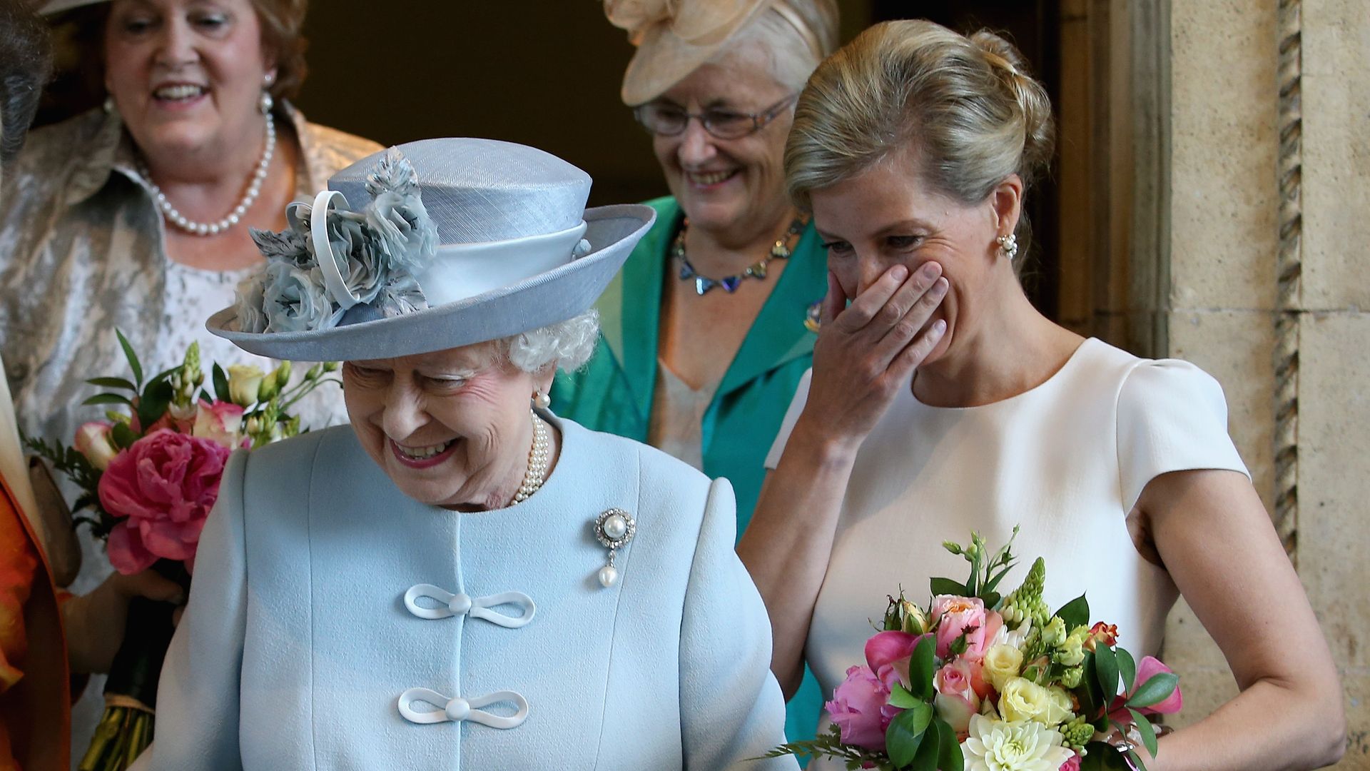 Sophie Wessex laughs as Queen Elizabeth II cuts a Women's Institute Celebrating 100 Years cake in 2015