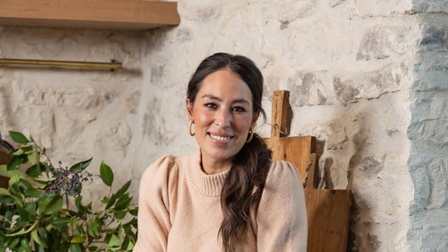 Joanna Gaines sits on a countertop