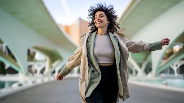 Smiling woman jumping high after successful job interview