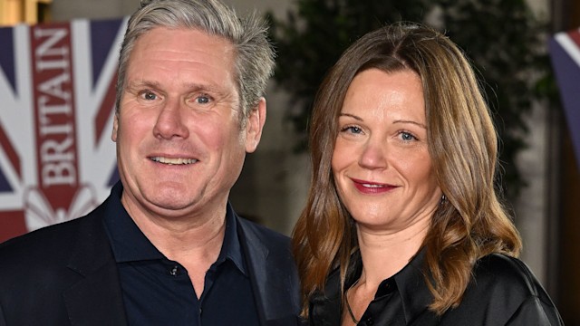 Keir Starmer in a black suit with his wife Victoria in a silk dress