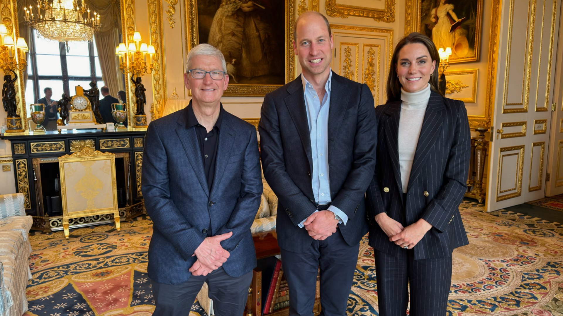 Apple boss Tim Cook posing with Prince William and Kate Middleton in pinstripe suit