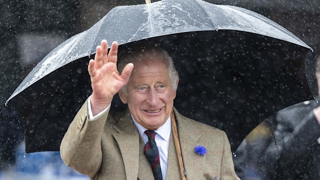 King Charles wearing a kilt and holding an umbrella as he arrives at 8 Doors Distillery