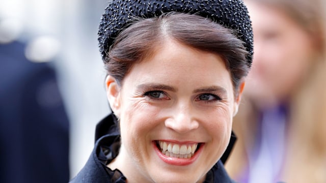Princess Eugenie grinning wearing black headband