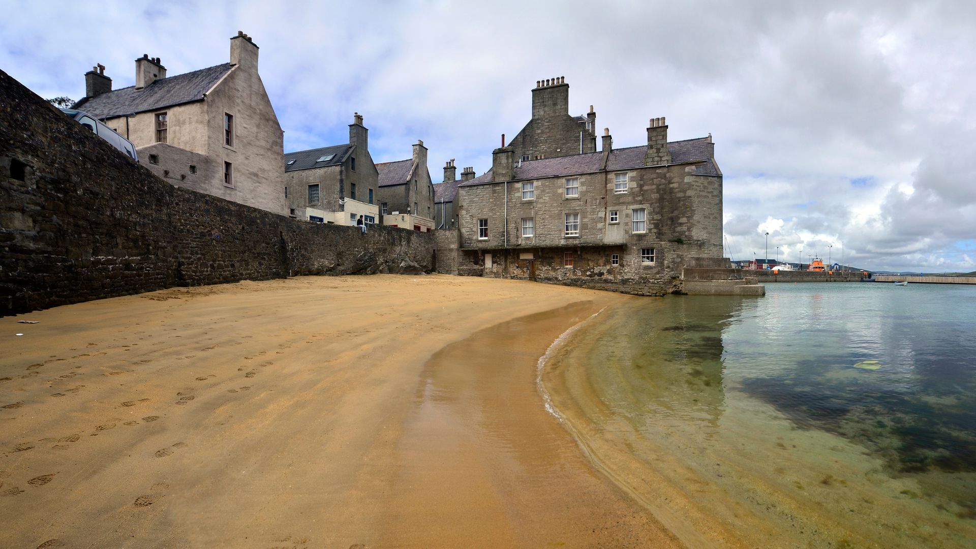 A yellow beach and buildings in Lerwick
