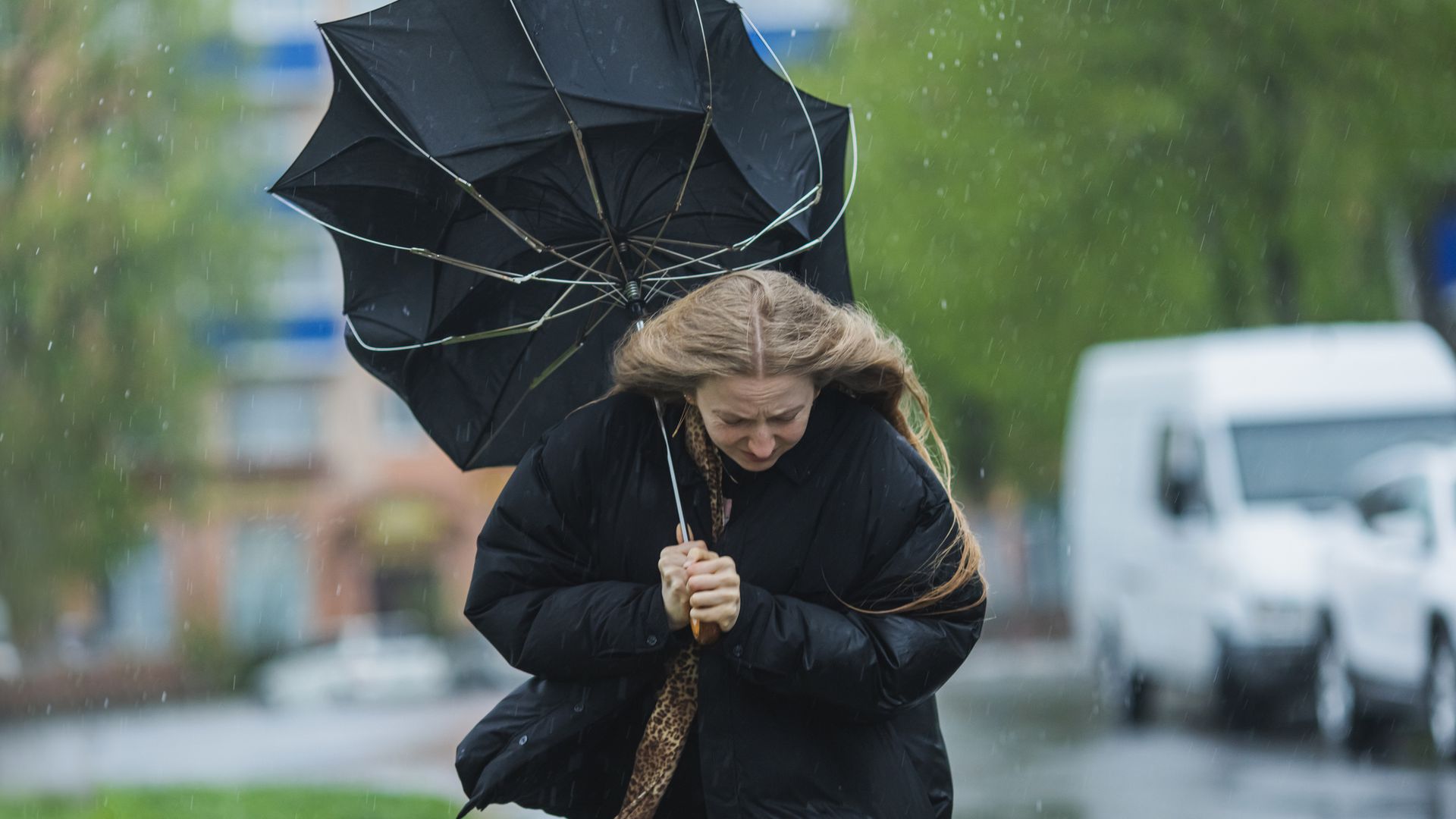 A woman walking with an umbrella turned inside out
