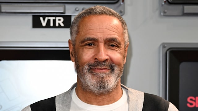 Daley Thompson in a white and black striped jacket