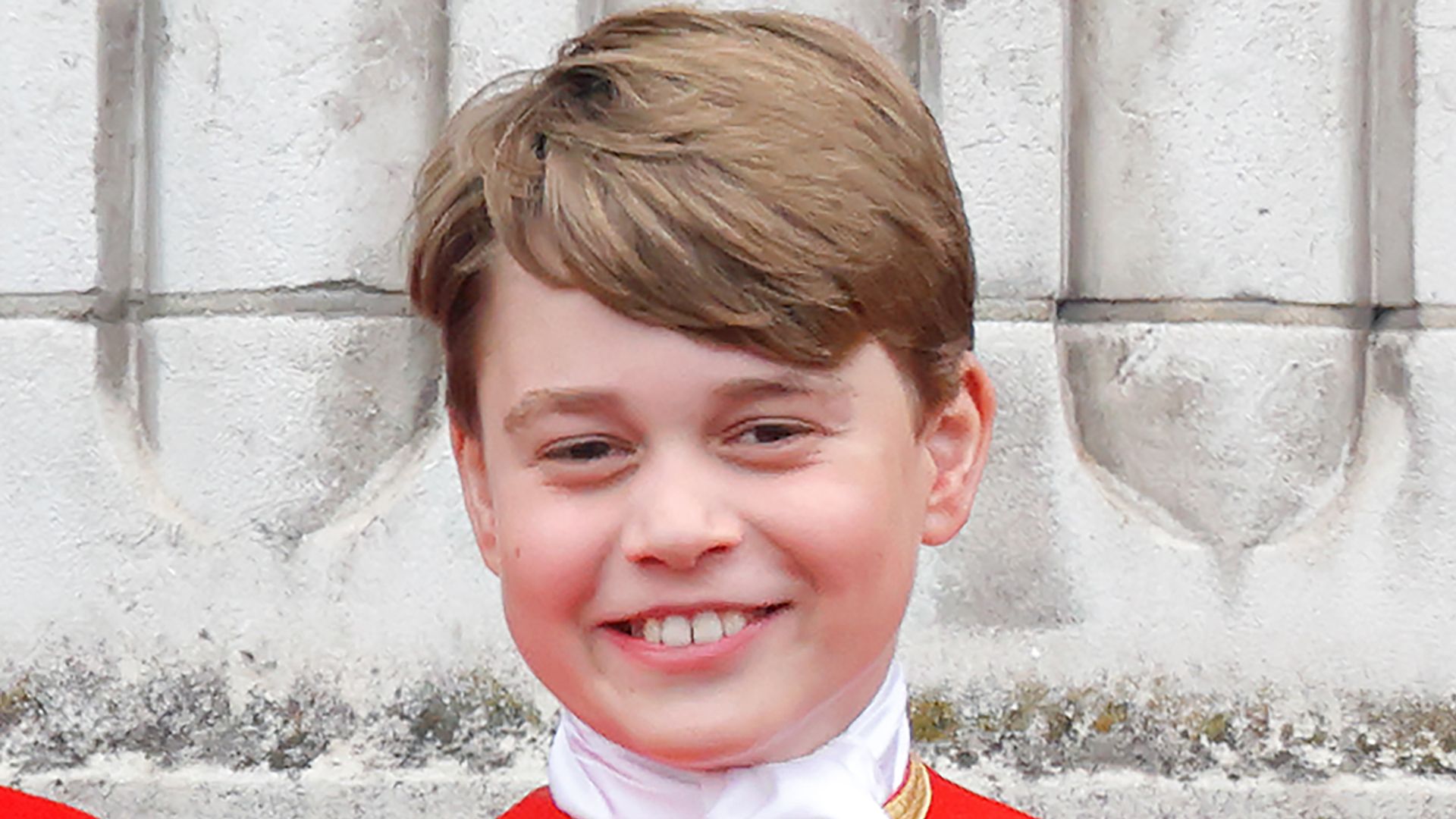 Prince George smiles in red uniform