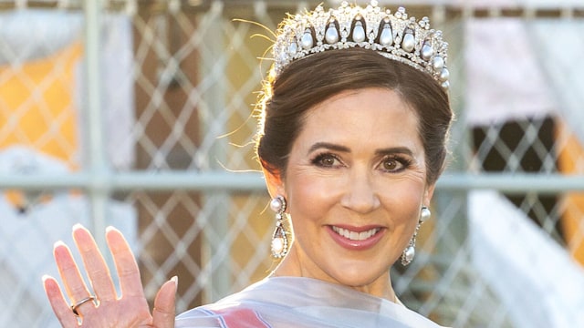 Queen Mary waving, wearing a lavender gown and pearl tiara