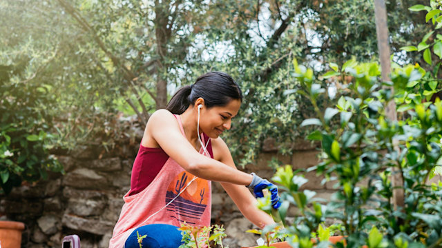 Cheerful woman gardening in backyard