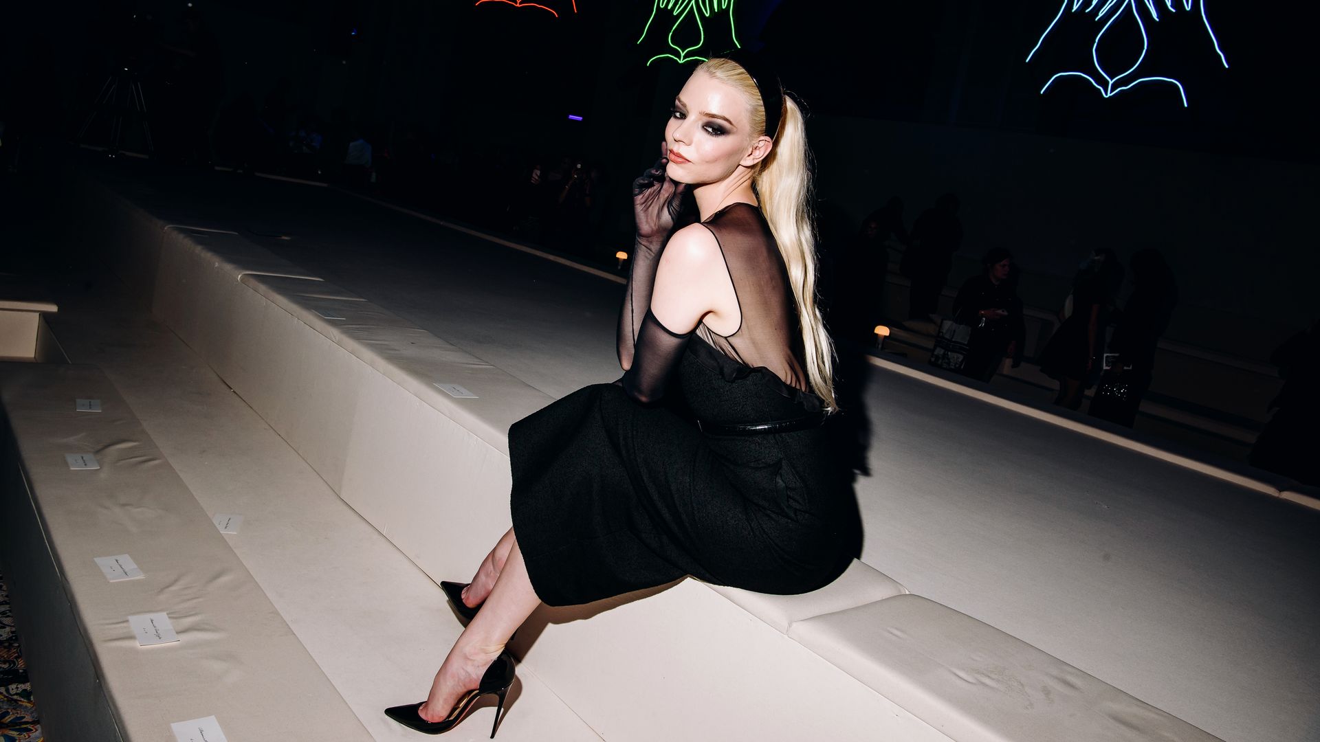 Anya Taylor-Joy seated in black semi-sheer Dior dress 