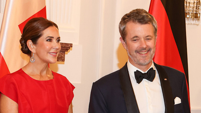 Queen Mary of Denmark in a red dress and King Frederik wearing a tuxedo