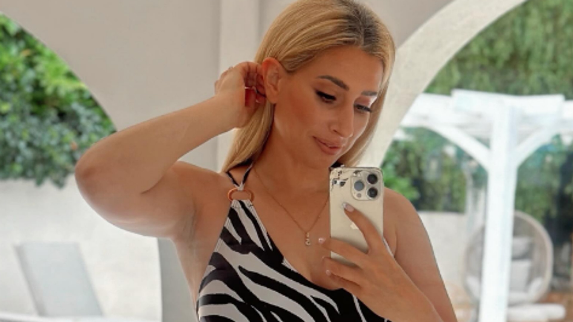 Stacey Solomon in zebra print swimsuit taking a mirror selfie with her pool in the background