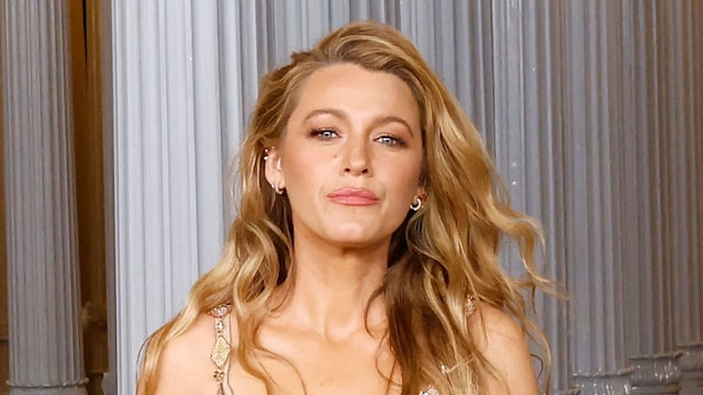 Blake Lively in chain dress with orange duvet shawl