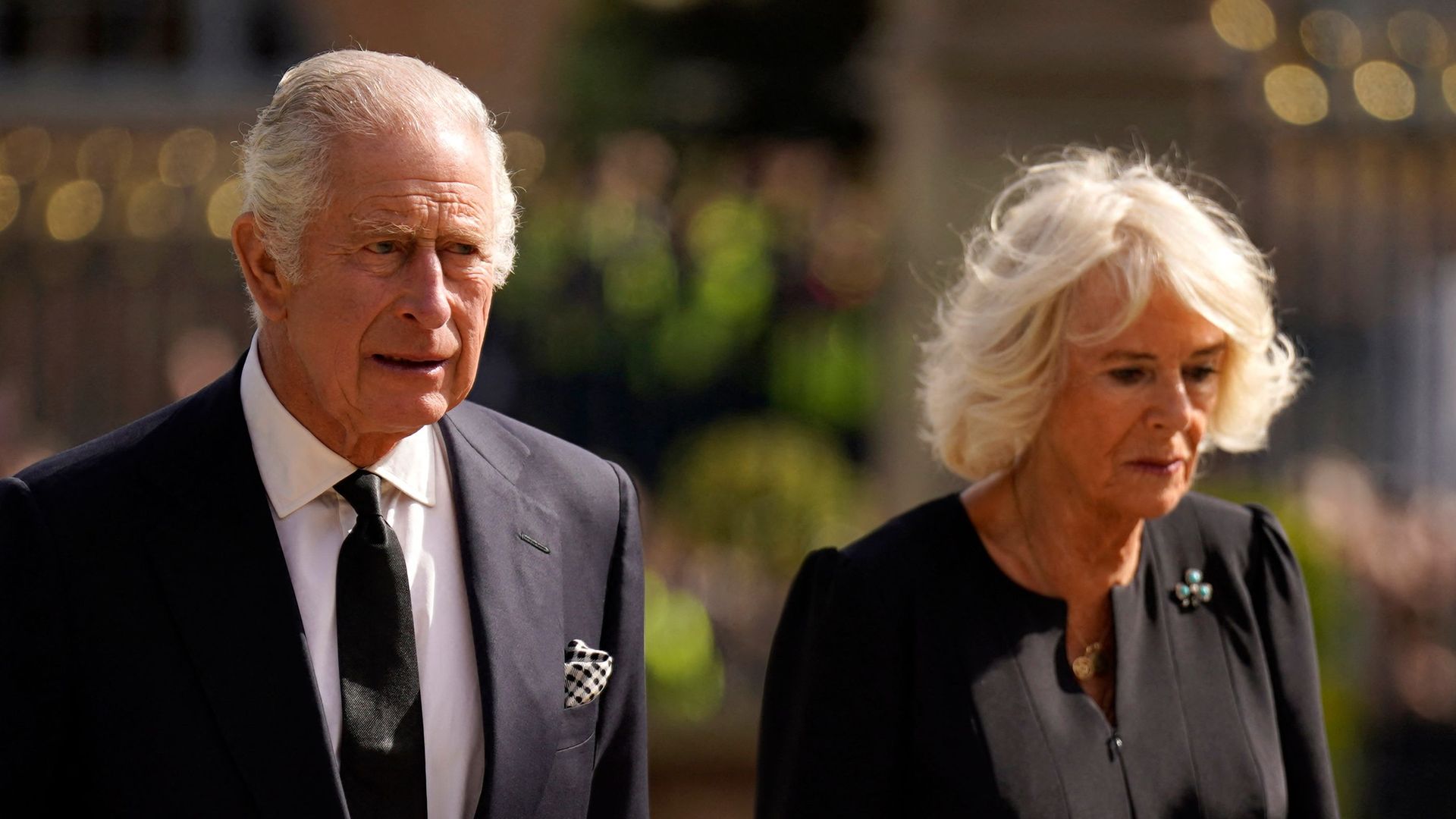 Britain's King Charles III and Britain's Camilla, Queen Consort look at flowers and tributes left in honour of his late mother Queen Elizabeth II