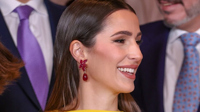 Princess Rajwa in a yellow dress and red earrings