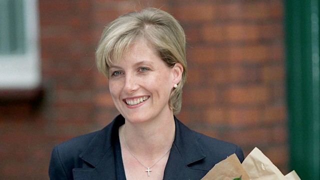 Sophie Rhys-jones in the 90s holding flowers smiling