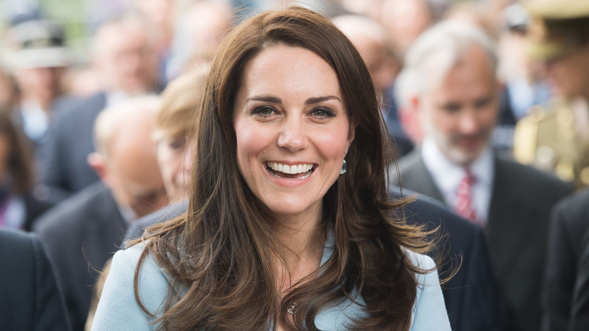Catherine, Duchess of Cambridge smiling in blue dress with shoulder lenght hair