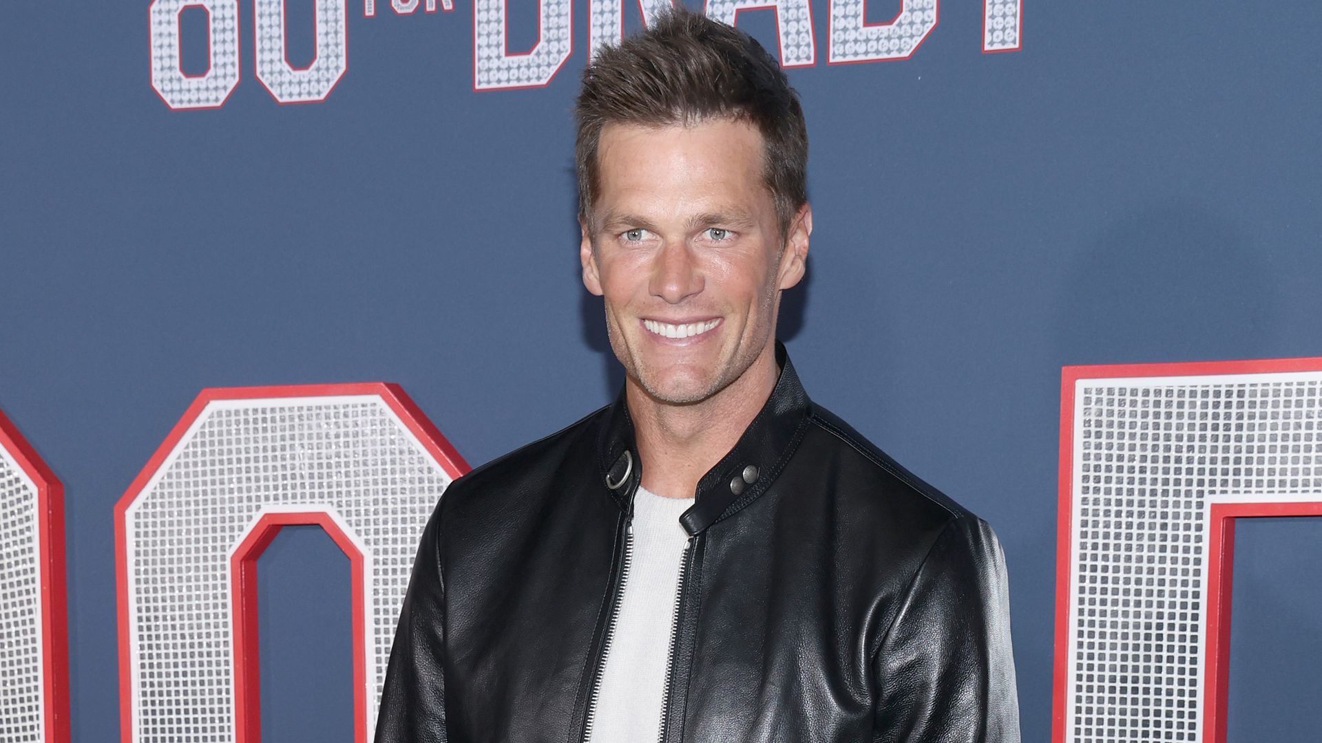 Tom Brady smiling at a red carpet event