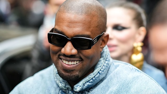 Kanye West smiling wearing sunglasses