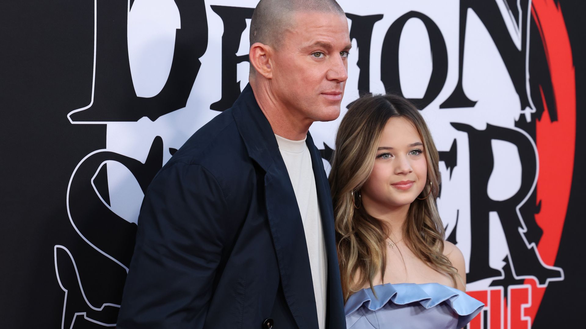 Channing Tatum in navy suit and Everly Tatum in blue dress on red carpet
