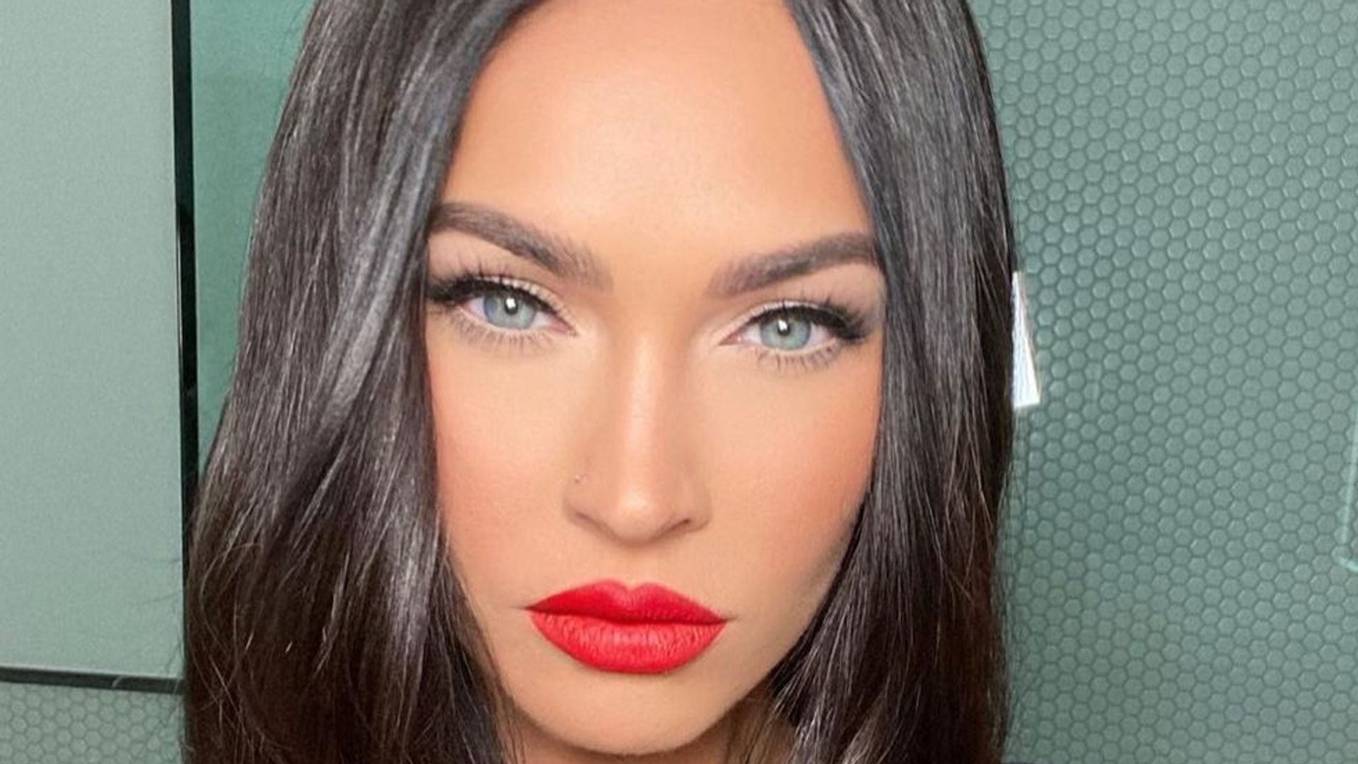 Megan Fox with straight black hair and red lipstick