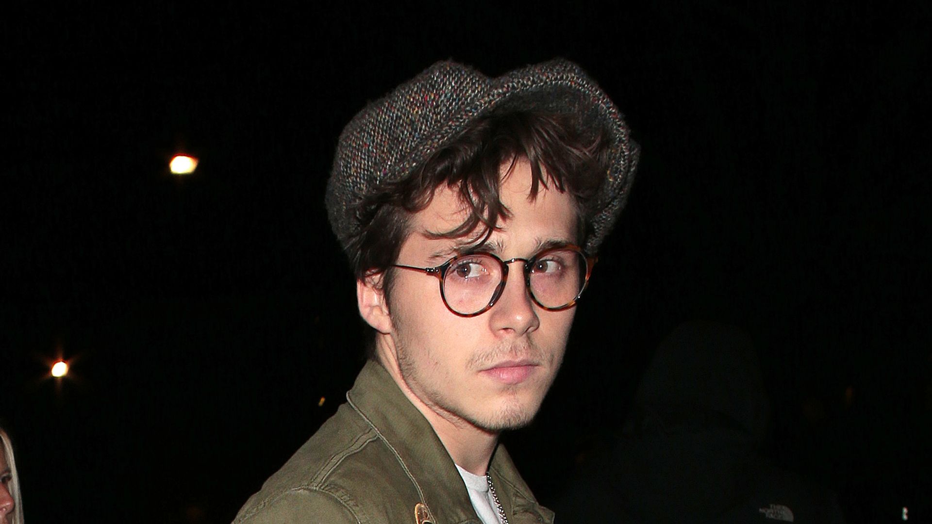 Brooklyn Beckham looking serious in a flat cap