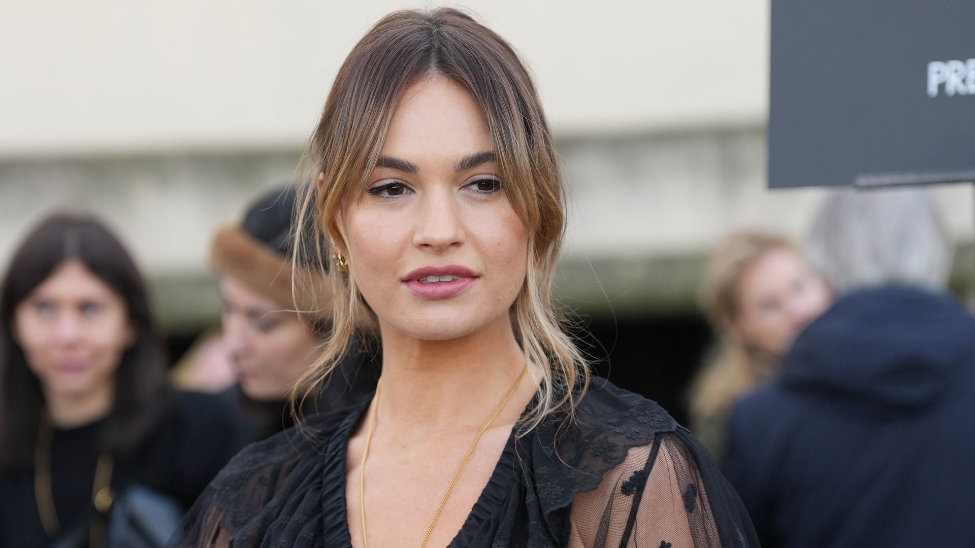 ily James wears gold earrings, black sheer mesh cropped Chloe top, white black lace bra, gold necklace, outside Chloe, 