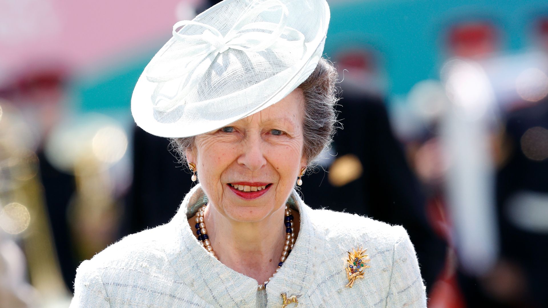 Princess Anne wearing checked coat and dress and red lipstick