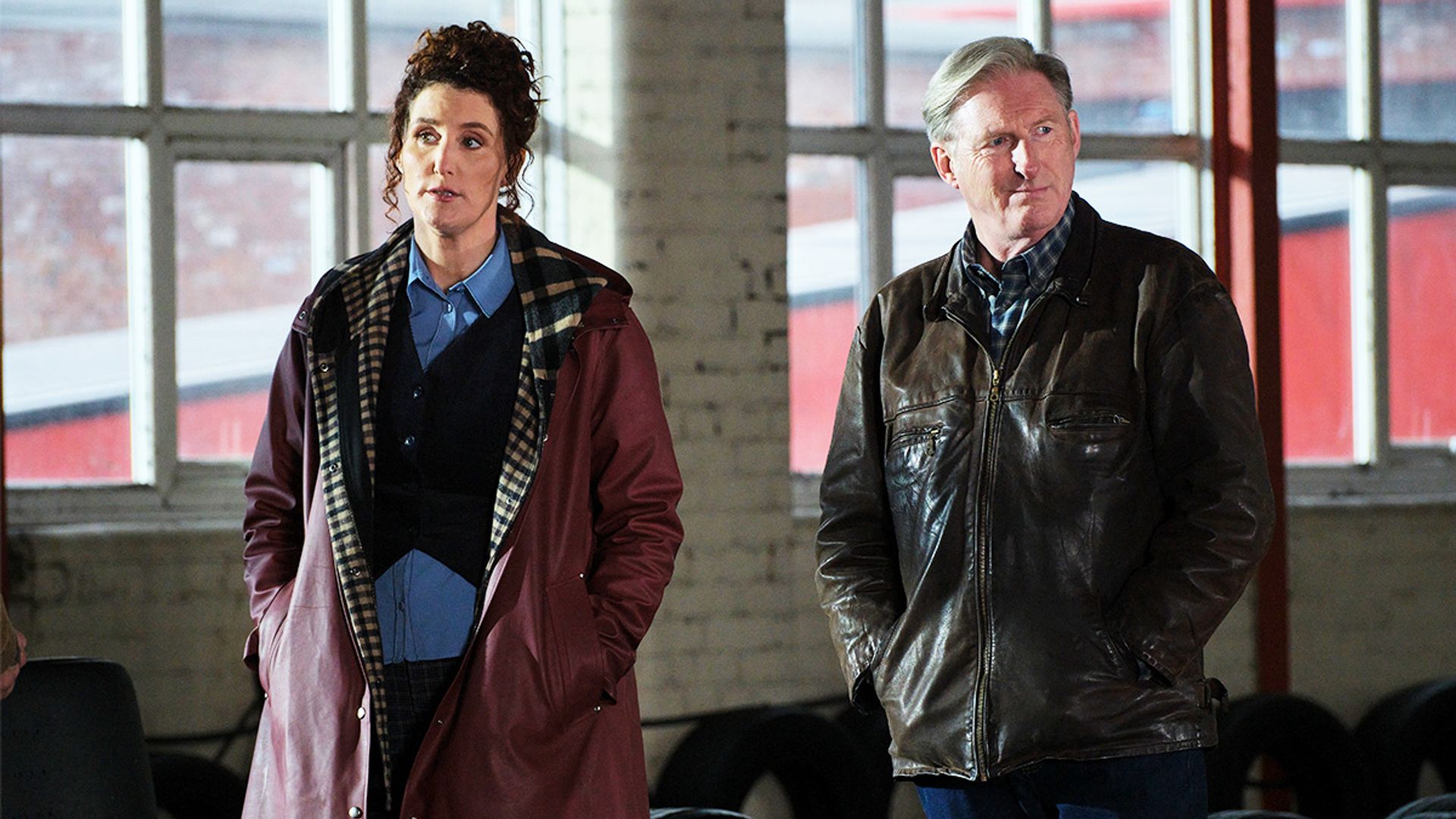 man and woman walking in dimly lit room
