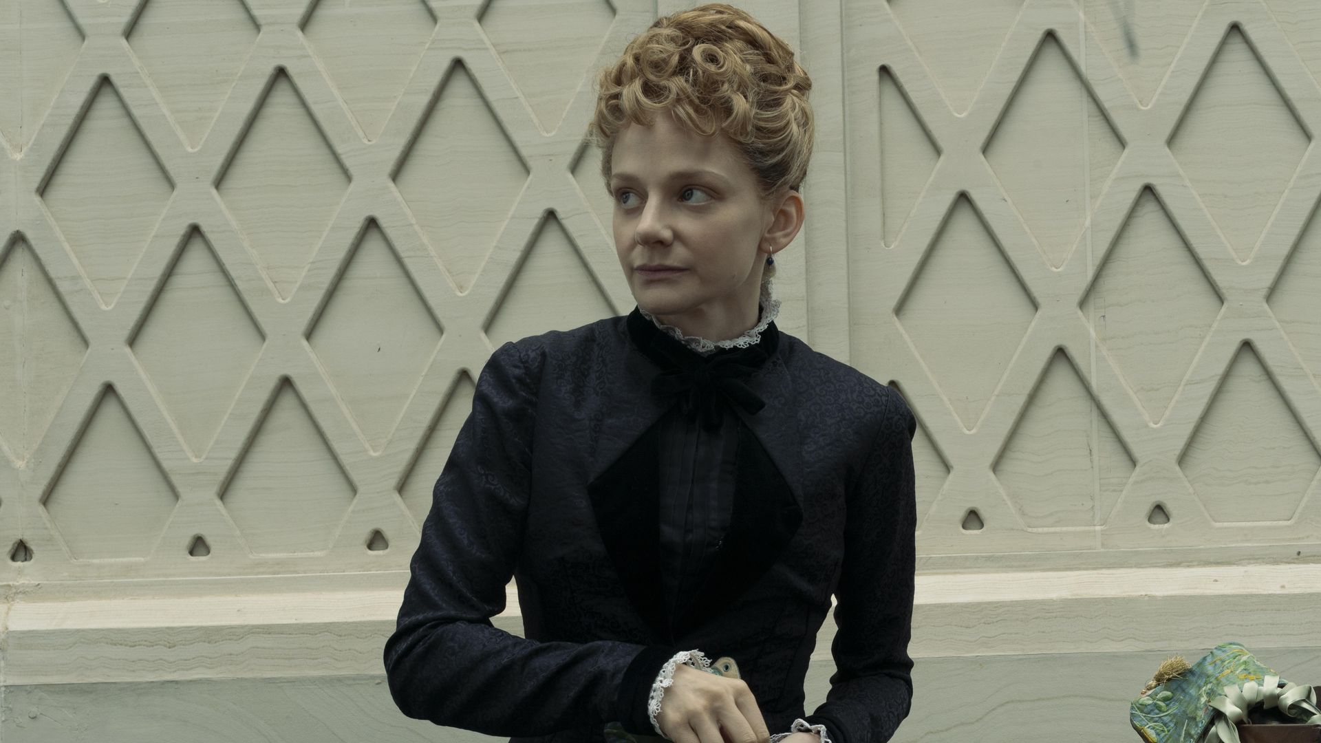 woman in black period dress holding shoe