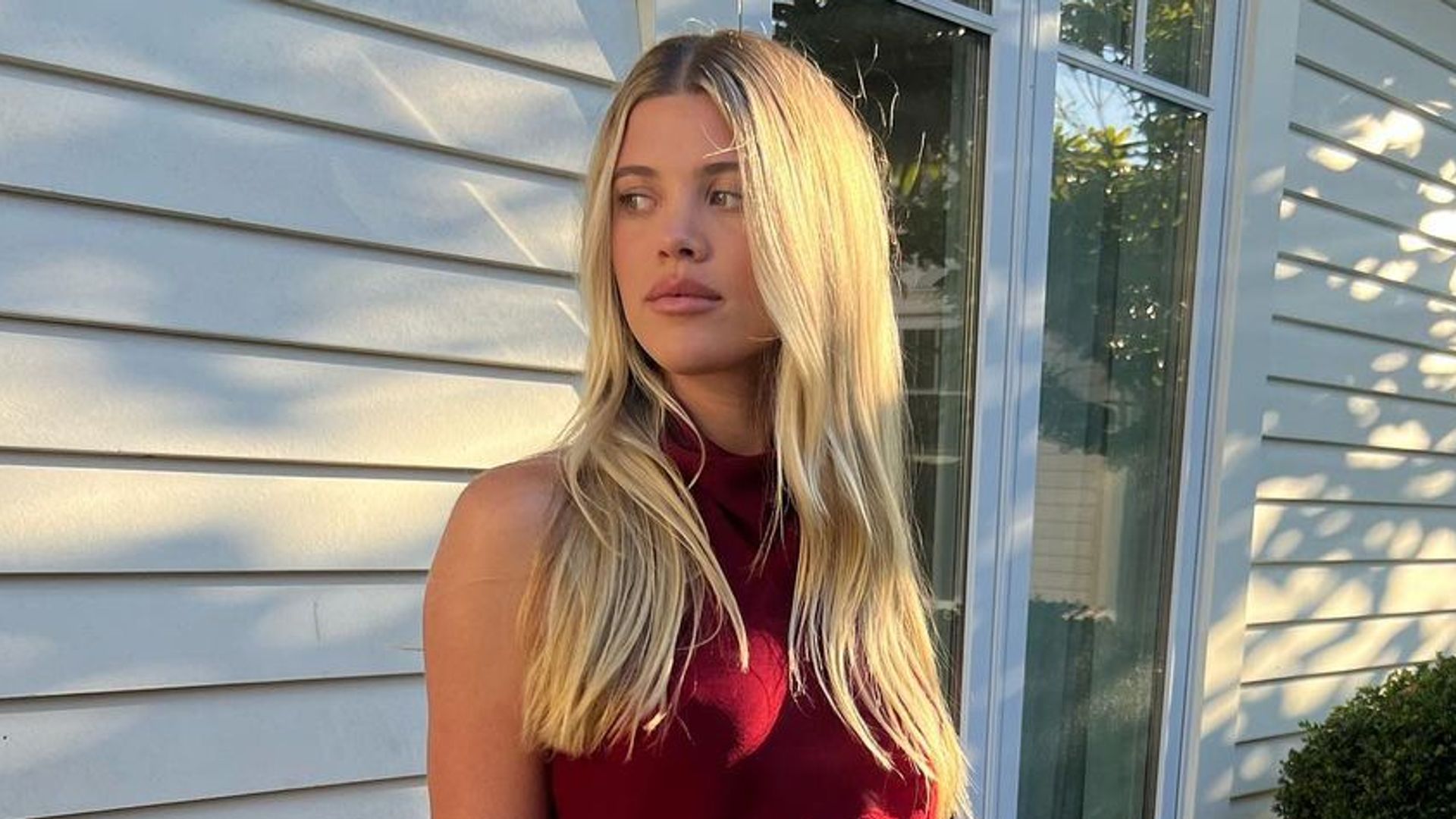 Sofia Richie in a red top looking away