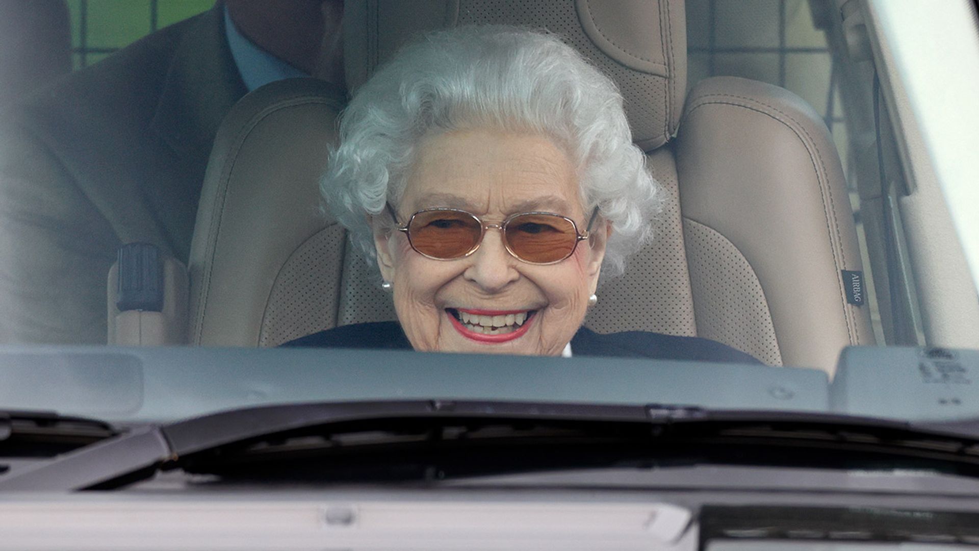 the queen smiling in car