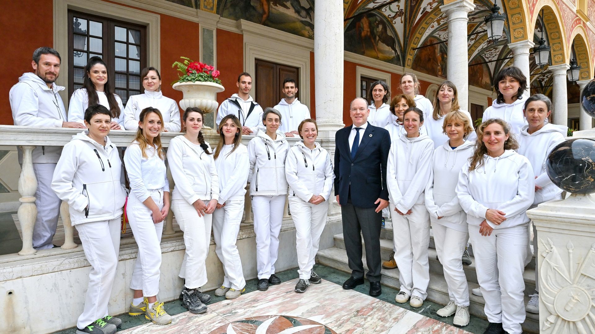 Prince Albert poses with some of the 22-strong team of restorers, painters, engineers, architects and photographers who carried out the extensive work