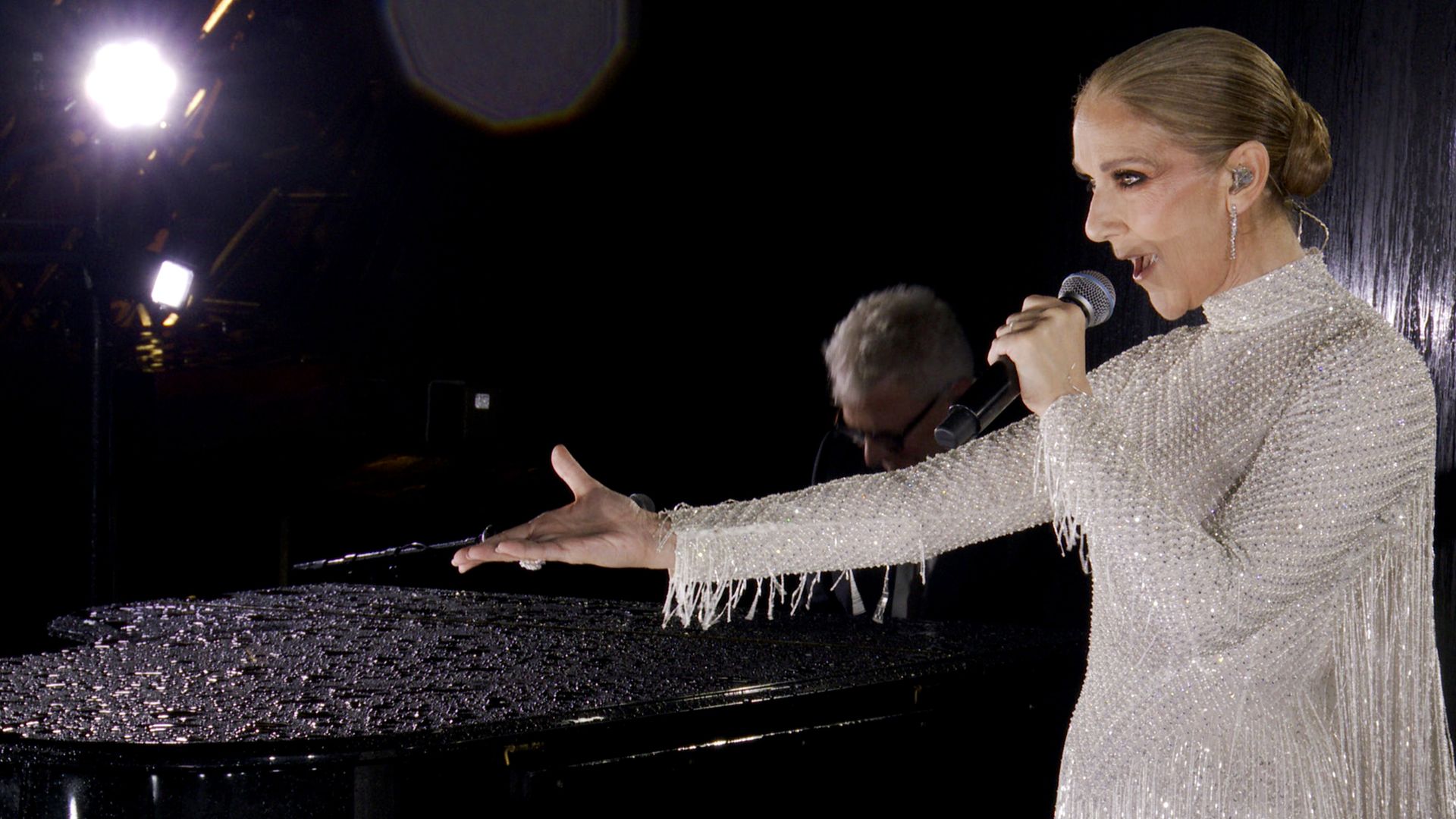 Celine Dion singing in a silver dress