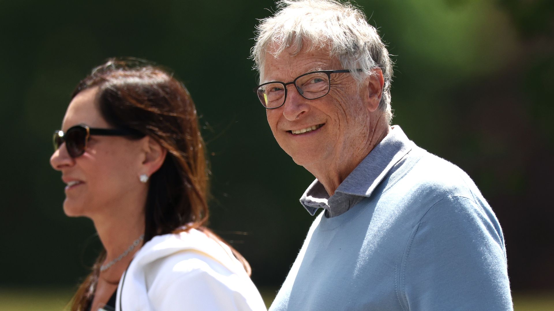 Bill Gates smiling walking next to Paula Hurd