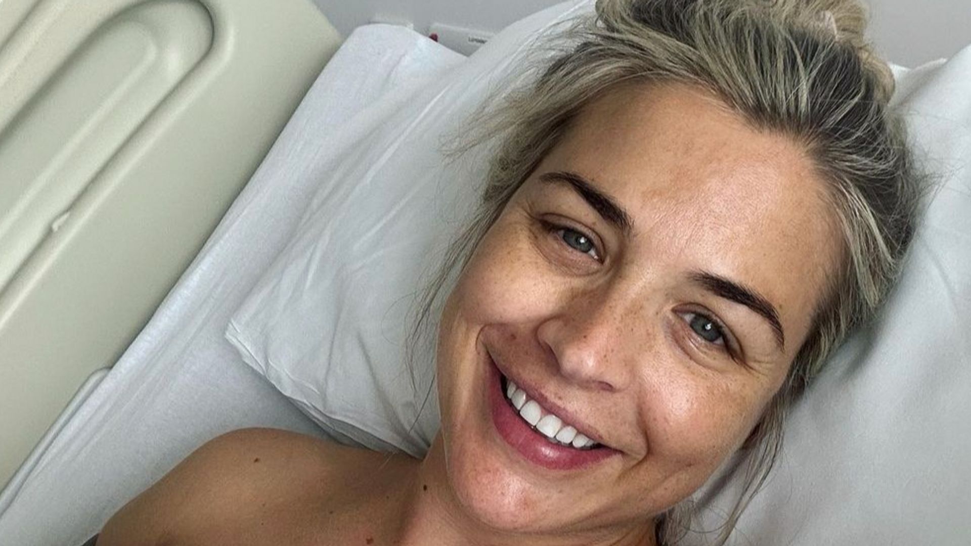 Gemma Atkinson lies in hospital bed smiling