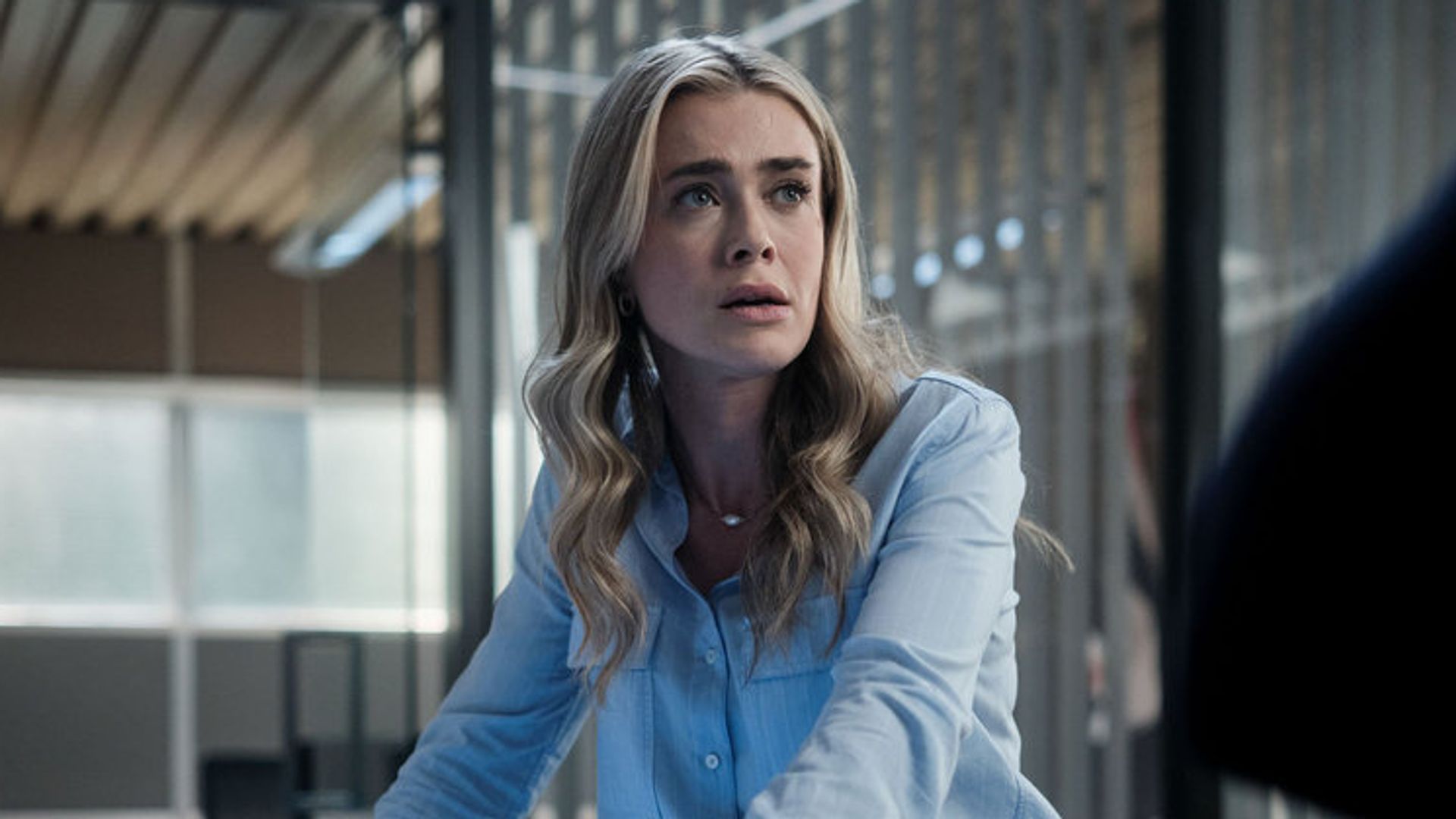 close-up blonde woman in blue shirt in office