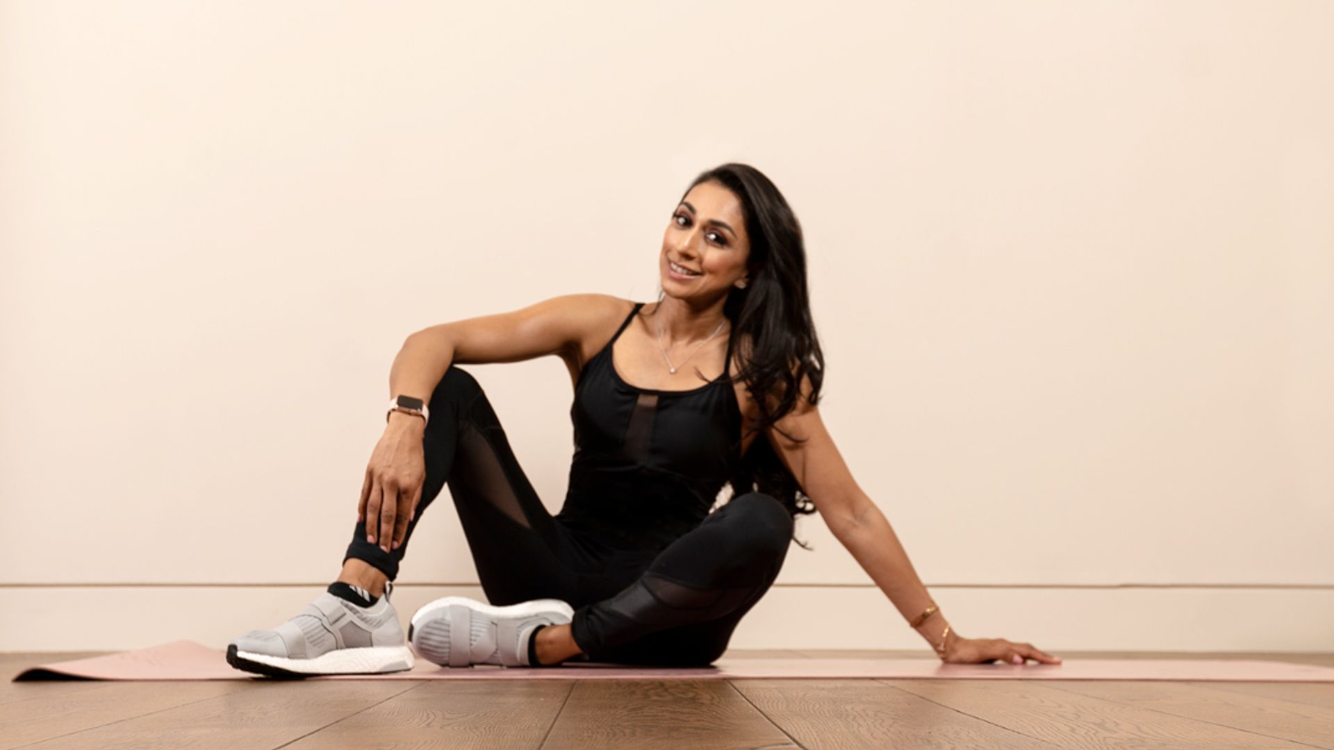 woman in exercise wear sitting on a yoga mat