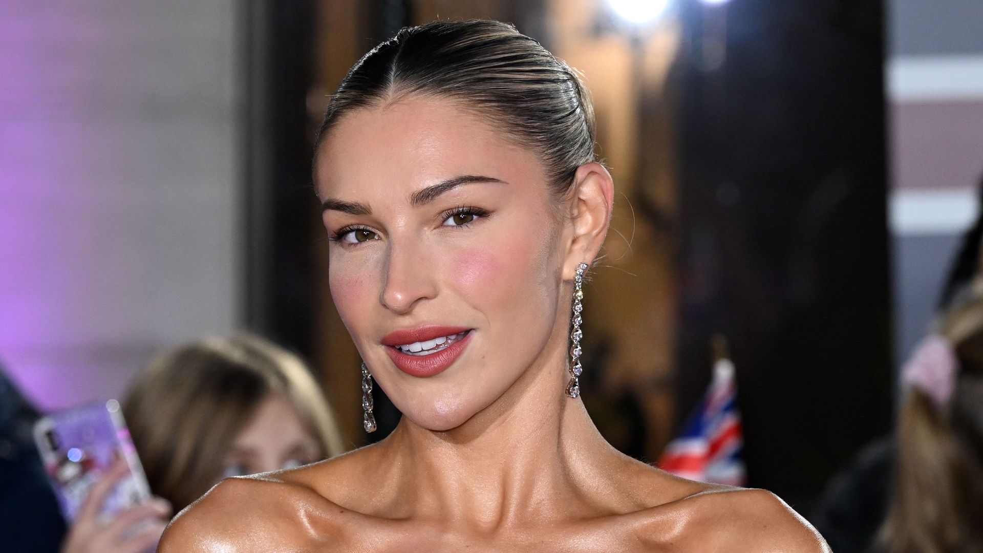 Zara McDermott looking serious on the red carpet in a black dress