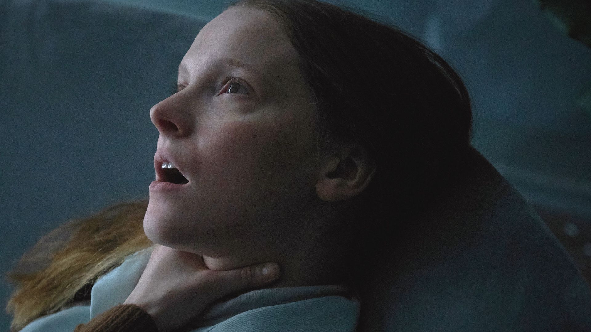 Morfydd Clark with a hand around her neck in a still from Saint Maud