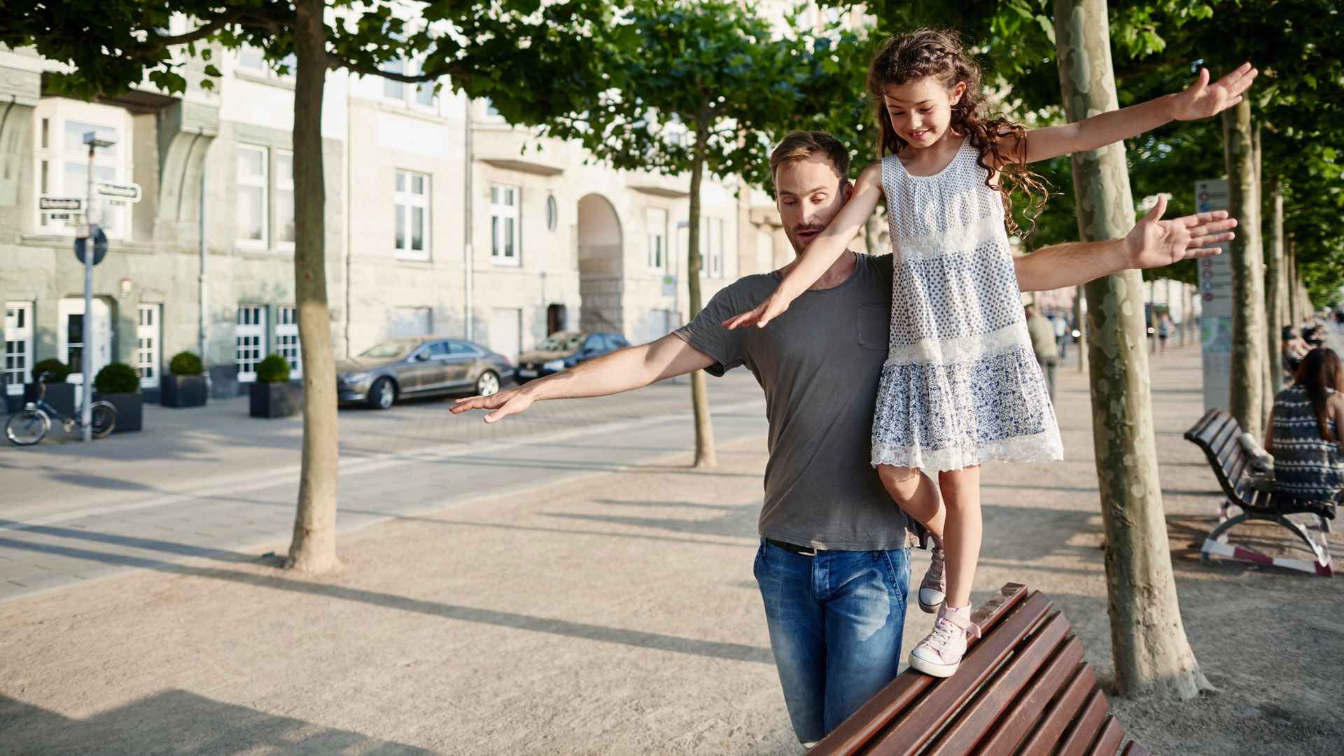 Father with daughter balancing on a bench