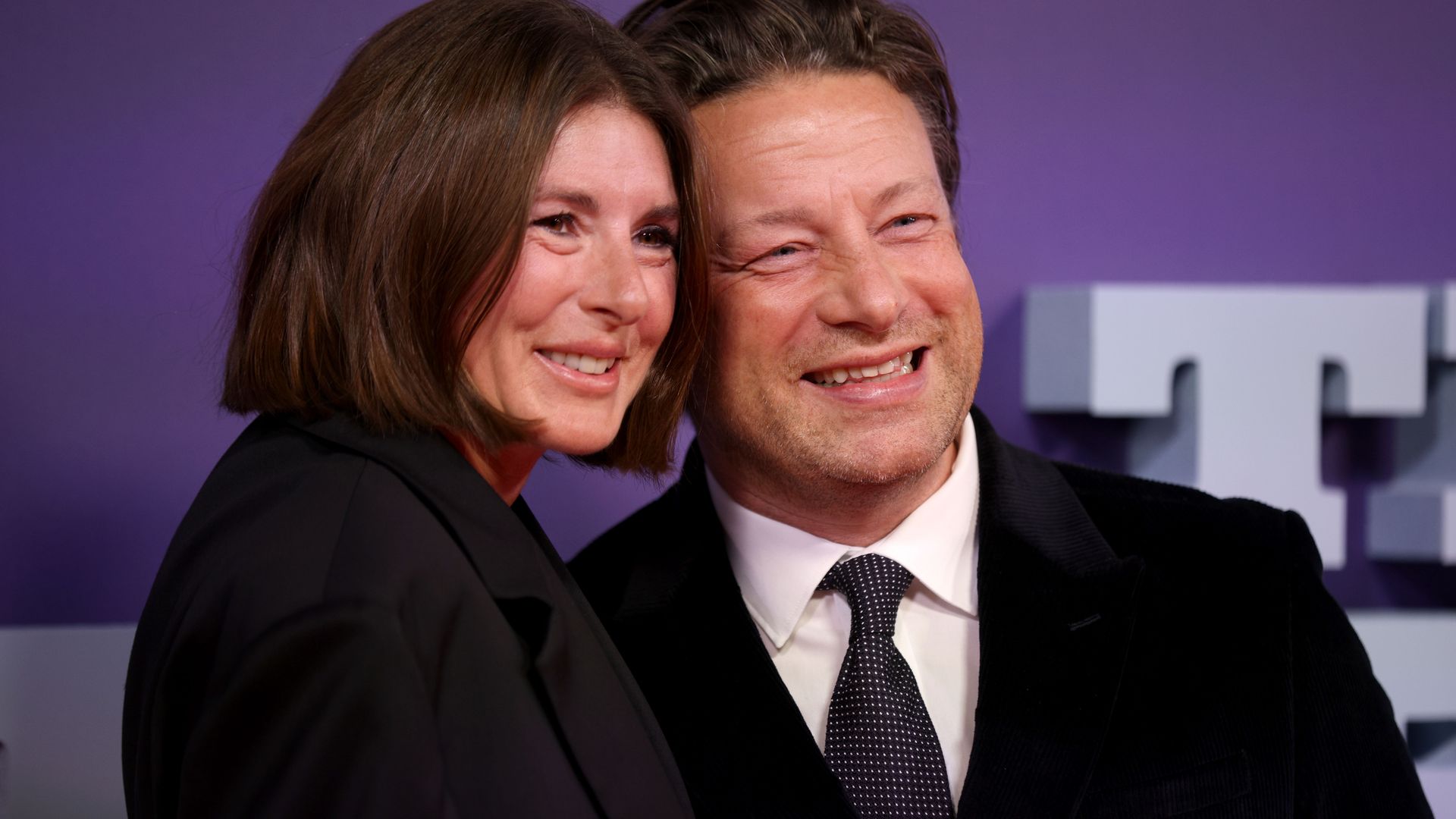 Jamie and Jools Oliver smiling on the red carpet