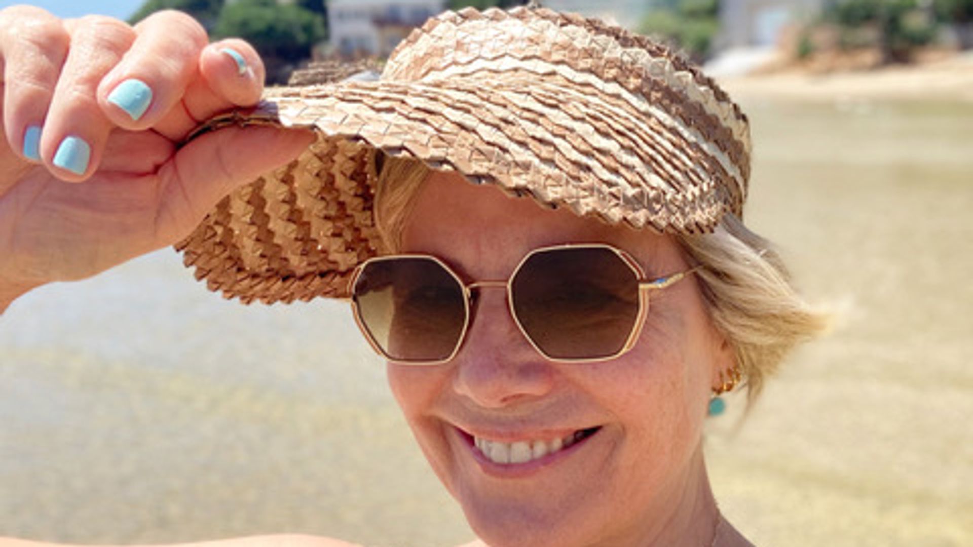 Woman on the beach in a sun hat smiling