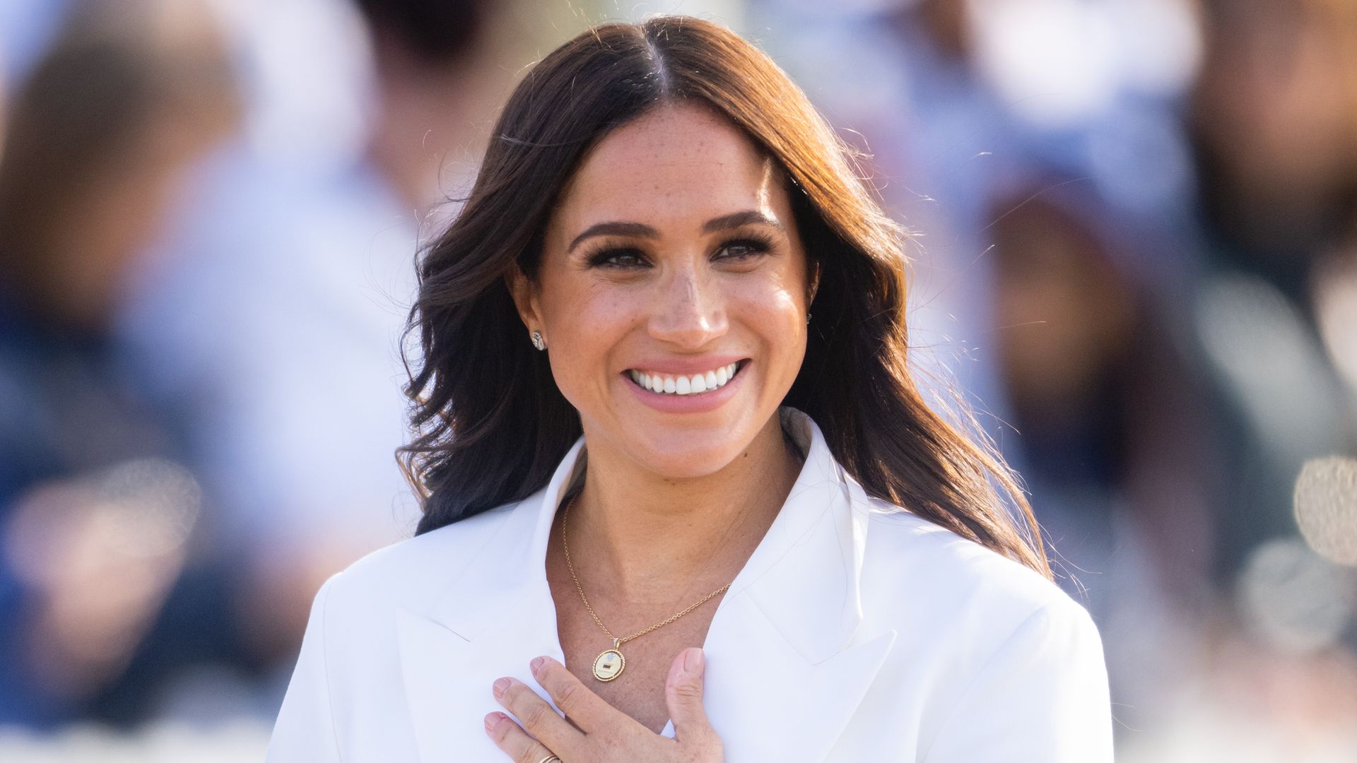 Meghan Markle smiling in white suit