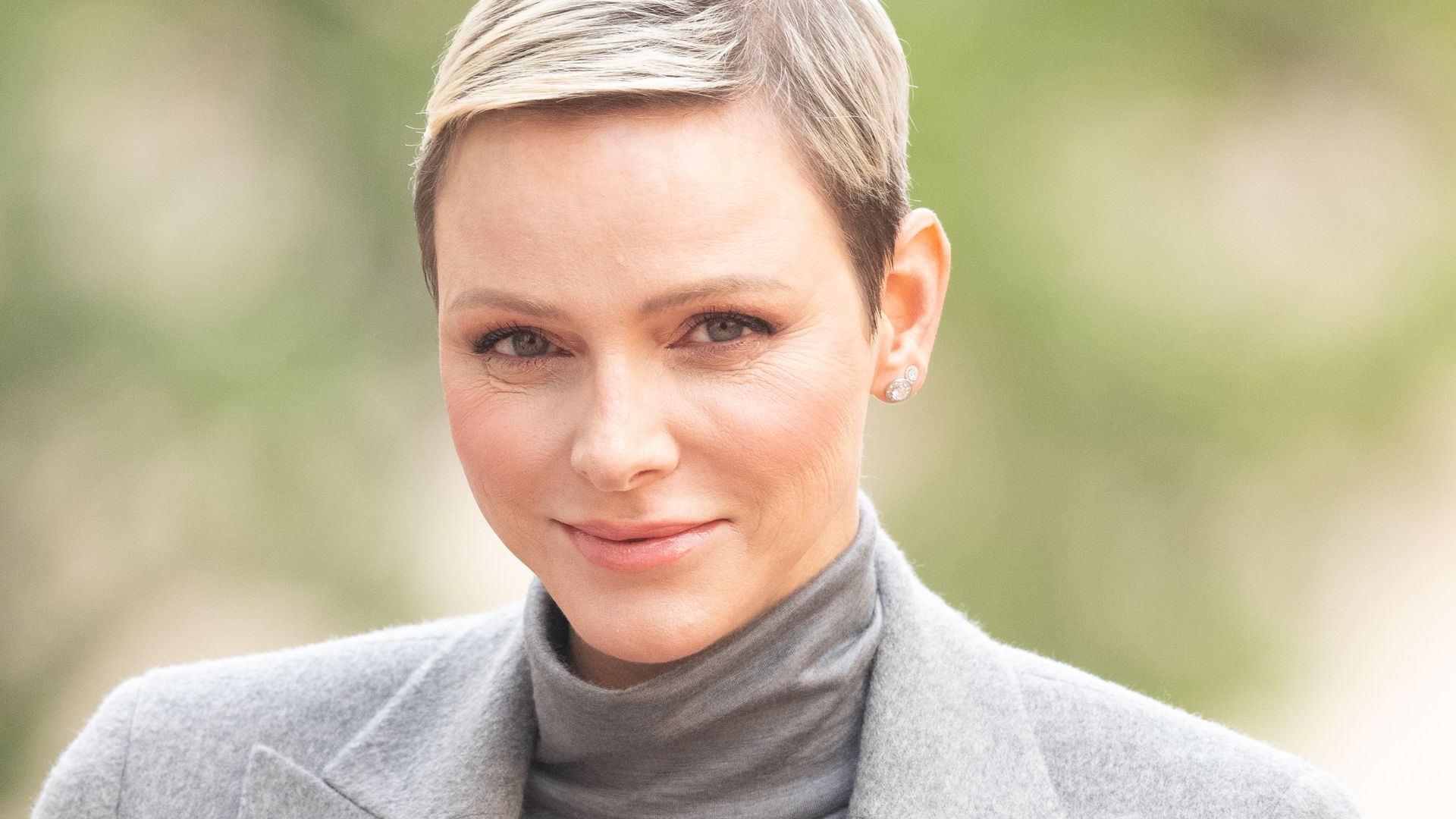 Princess Charlene in grey coat and roll neck