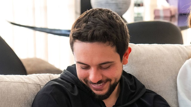 Crown Prince Hussein cradling a baby