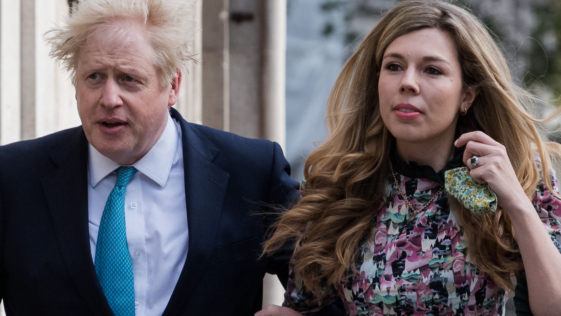 Boris Johnson in a suit with his wife Carrie in a floral dress