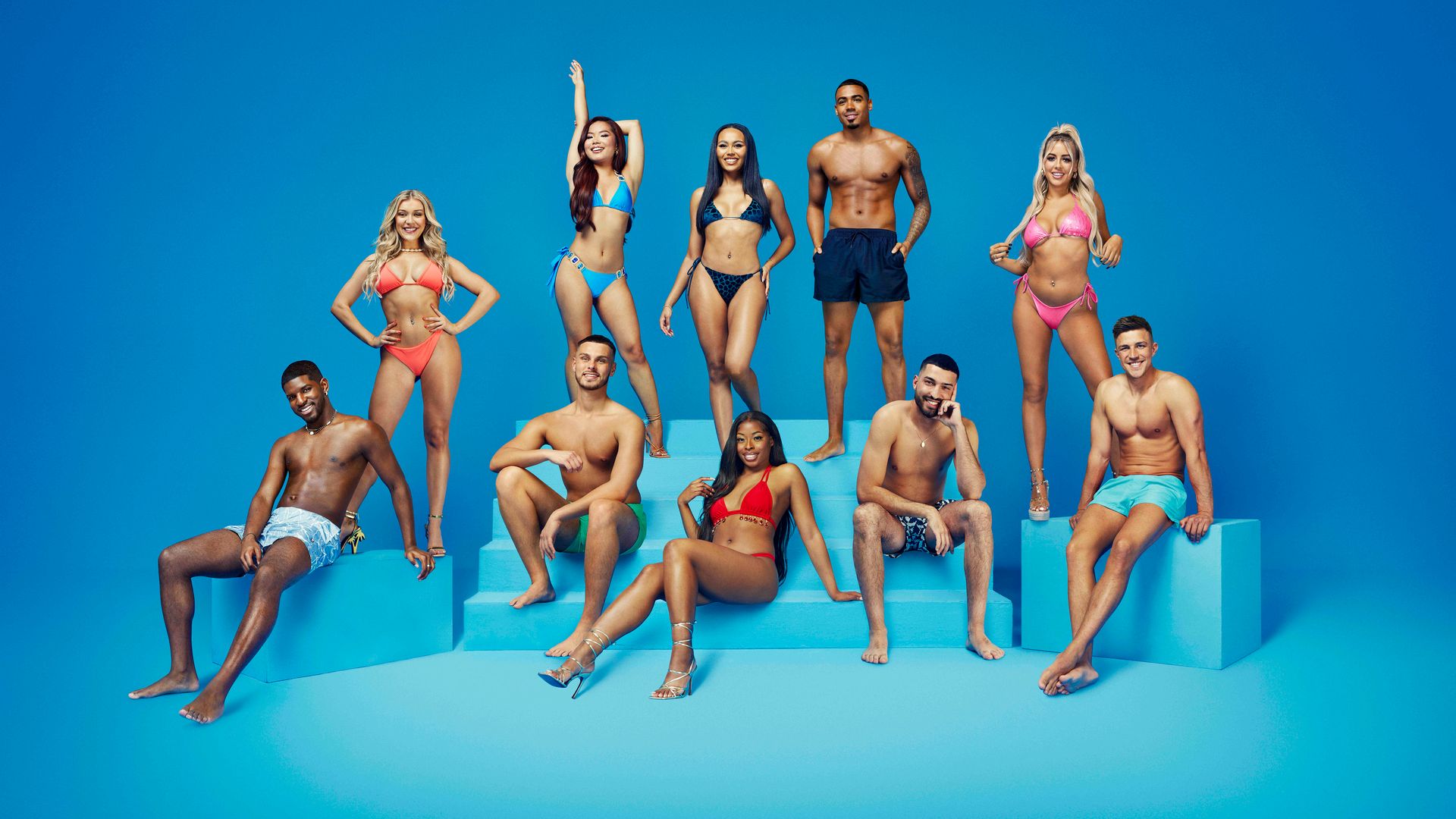 Love Island contestants pose in front of blue background for official photos